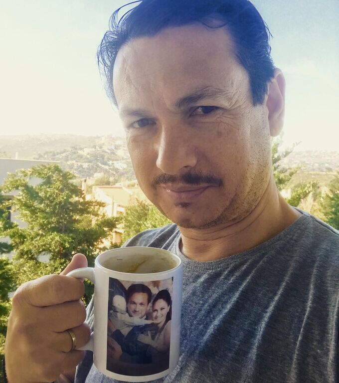 Πίνει καφέ σε κούπα που απεικονίζεται η οικογένειά του