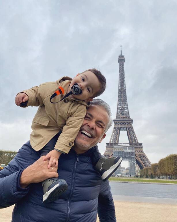 Μπαμπάς και γιος στο Παρίσι, φωτογραφίζονται κάτω από τον πύργο του Άιφελ.
